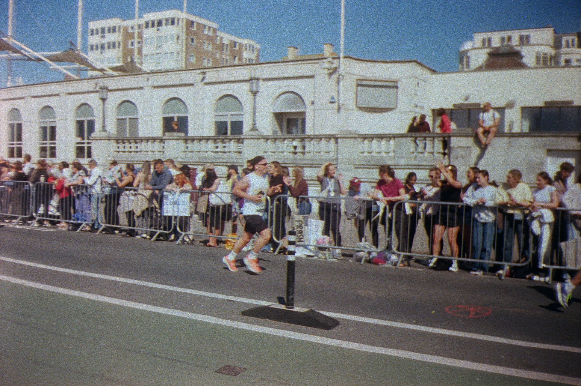A runner in a marathon, cheered on by a crowd along the seafront