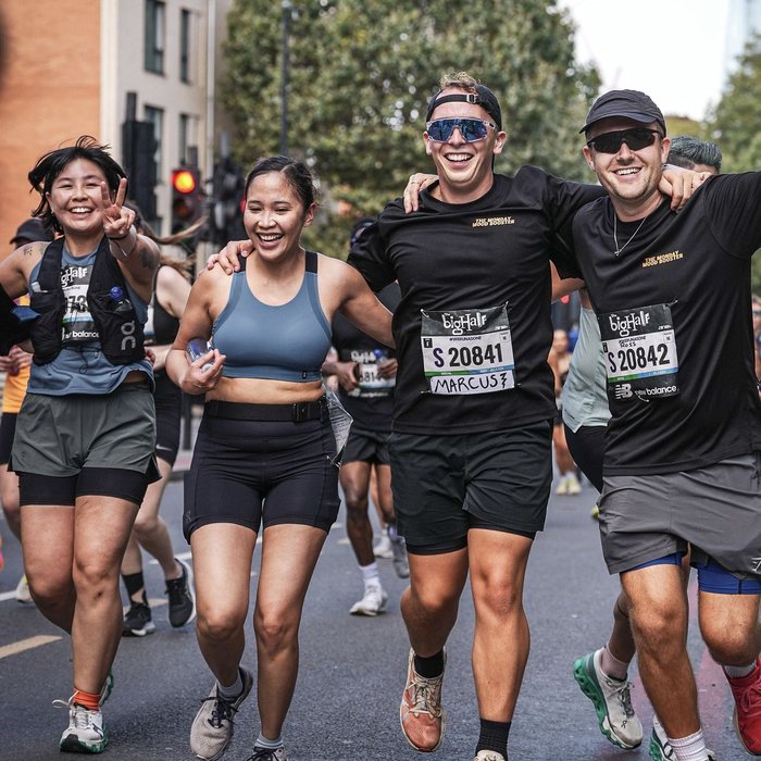 Runners embracing and smiling together mid race at The Big Half